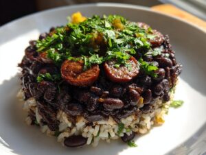 A molded serving of amazing 1-pot black beans and rice topped with sliced sausage and fresh cilantro.