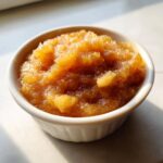 Close-up of chunky, spiced homemade applesauce served in a small white ramekin dish.