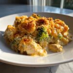 A close-up serving of creamy chicken broccoli rice casserole topped with golden brown breadcrumbs.