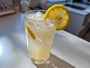 A tall glass filled with crushed ice and homemade lemonade, garnished with a bright lemon slice.