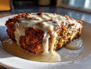 Close-up of a serving of low-calorie chicken fried steak covered in creamy white gravy on a white plate.