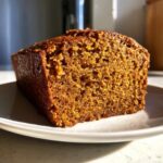 Close-up of a moist, dark orange slice of easy pumpkin bread showing its tender, open crumb structure.