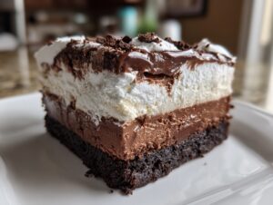 Close-up of a rich slice of Mississippi Mud Pie showing dark crust, chocolate filling, and whipped topping.