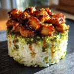 Close-up of a beautifully plated honey lime chicken & avocado rice stack with glazed chicken on top.